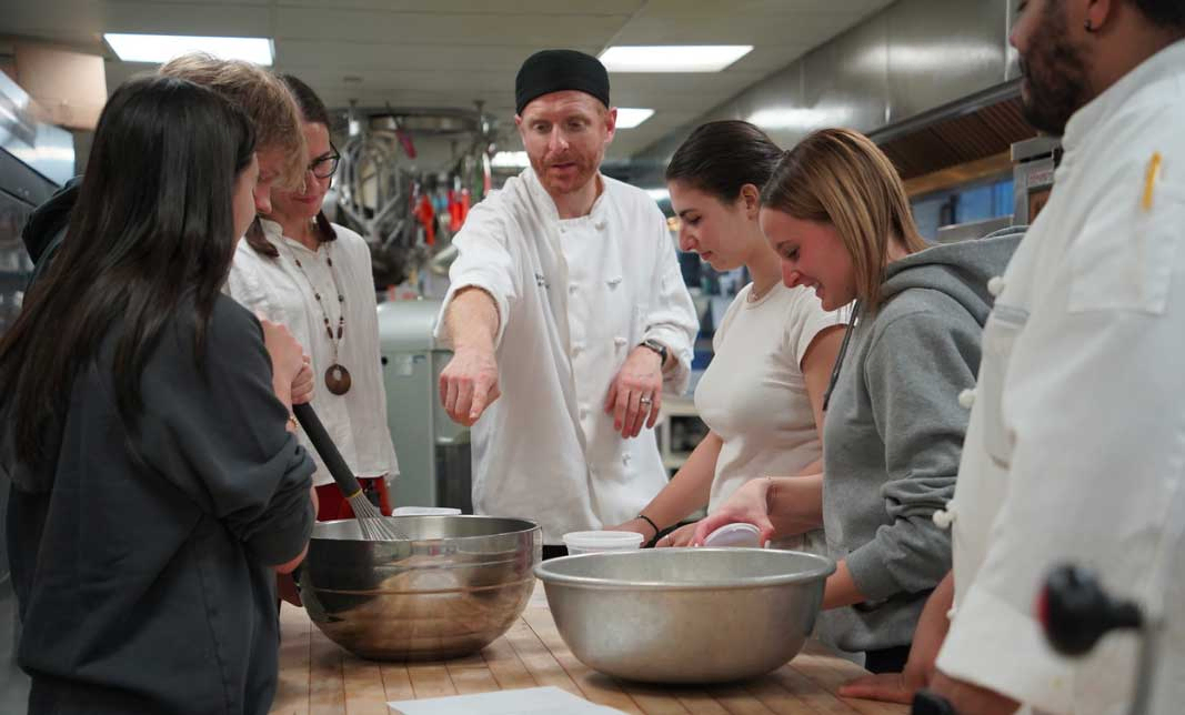 Chef talking to a group of students in kitchen
